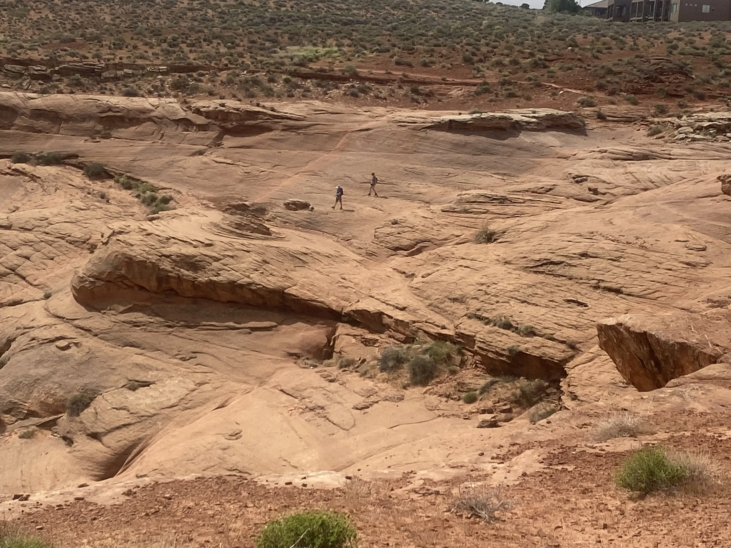 Hikers exploring Page Rim Trail along slick rock terrain