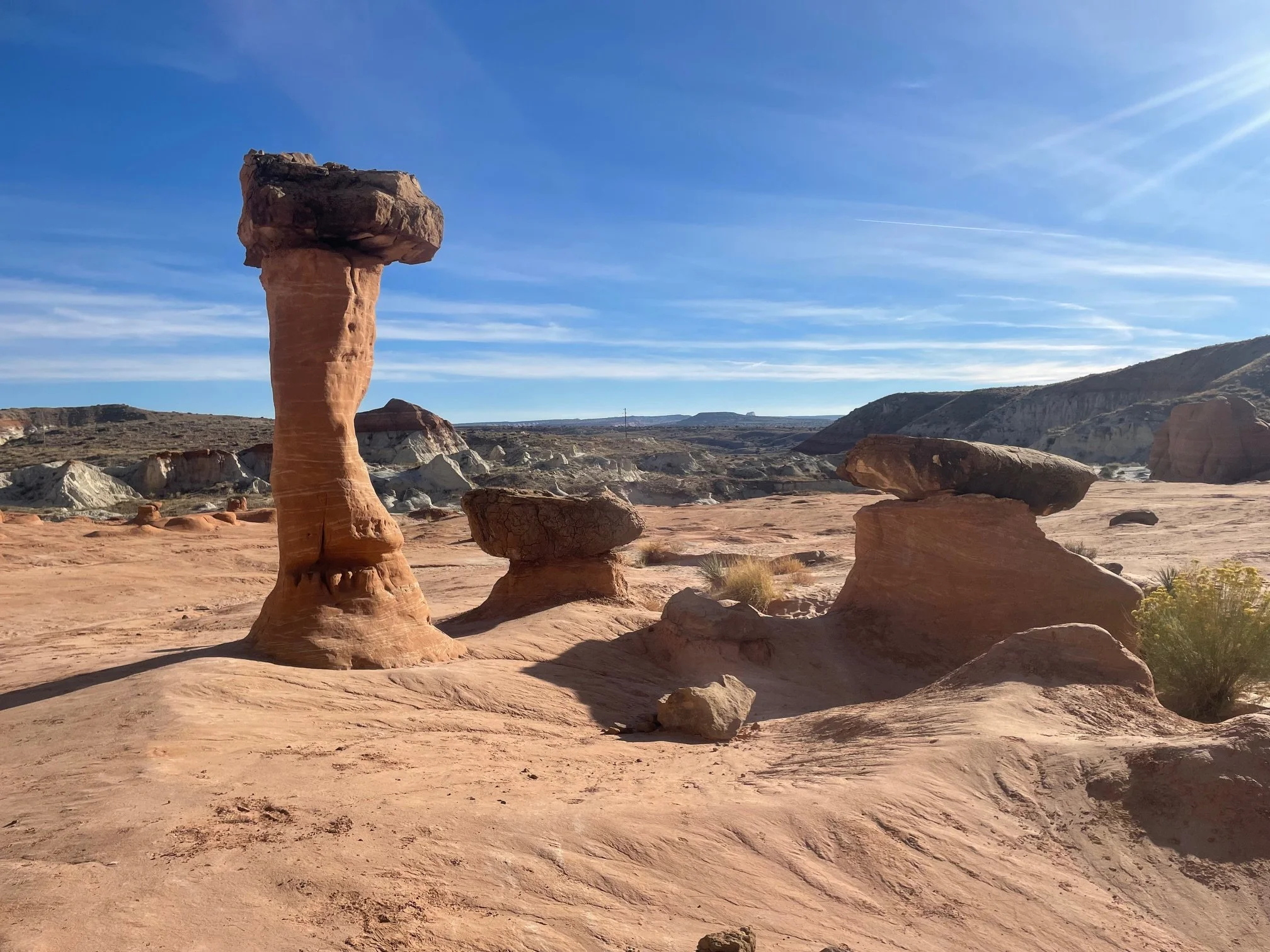 Tall sandstone hoodoo with two smaller sandstone hoodoos on Toadstools Trail