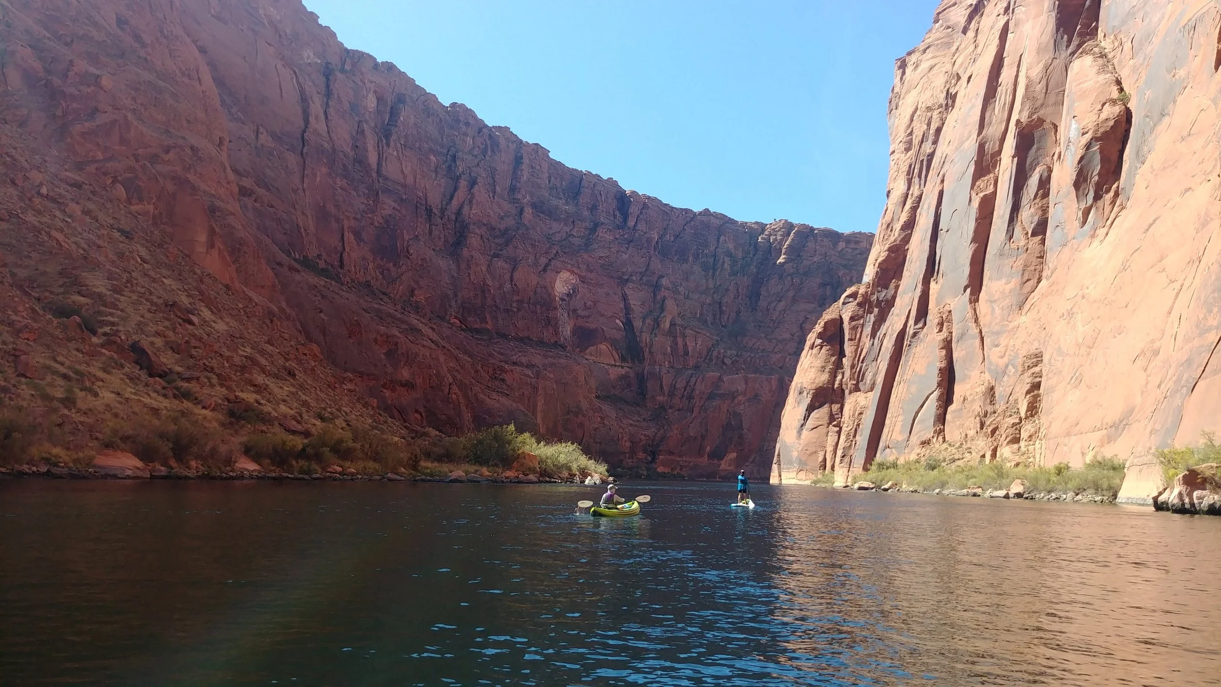 Paddlers in an inflatable kayak and stand up paddle board in the Colorado River gorge