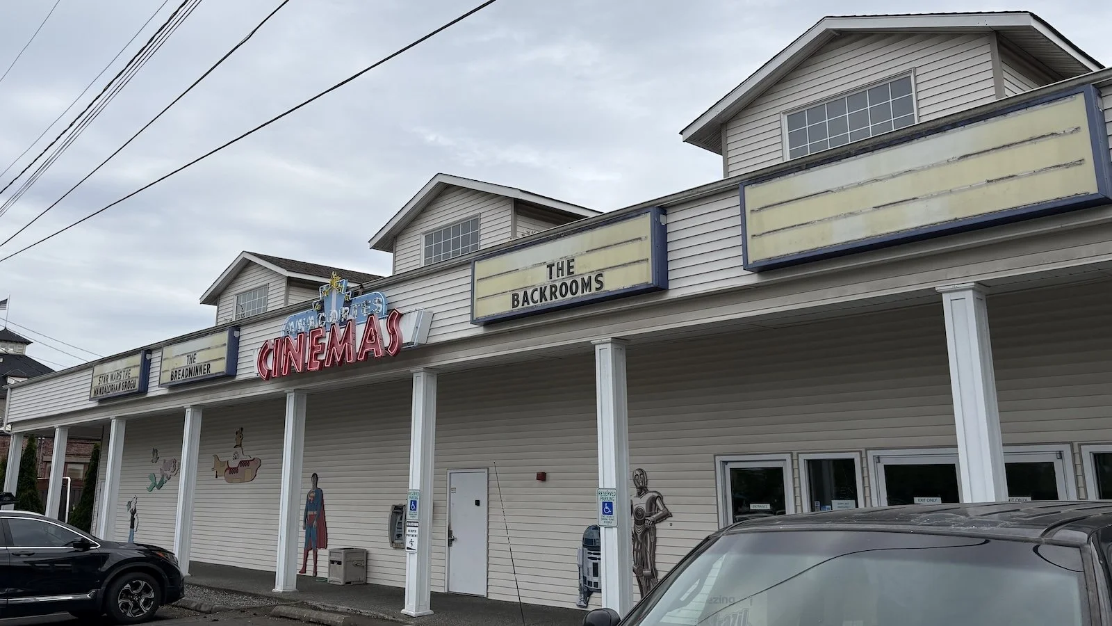 facade of Anacortes Cinemas with columns holding up the marquees and neon sign.