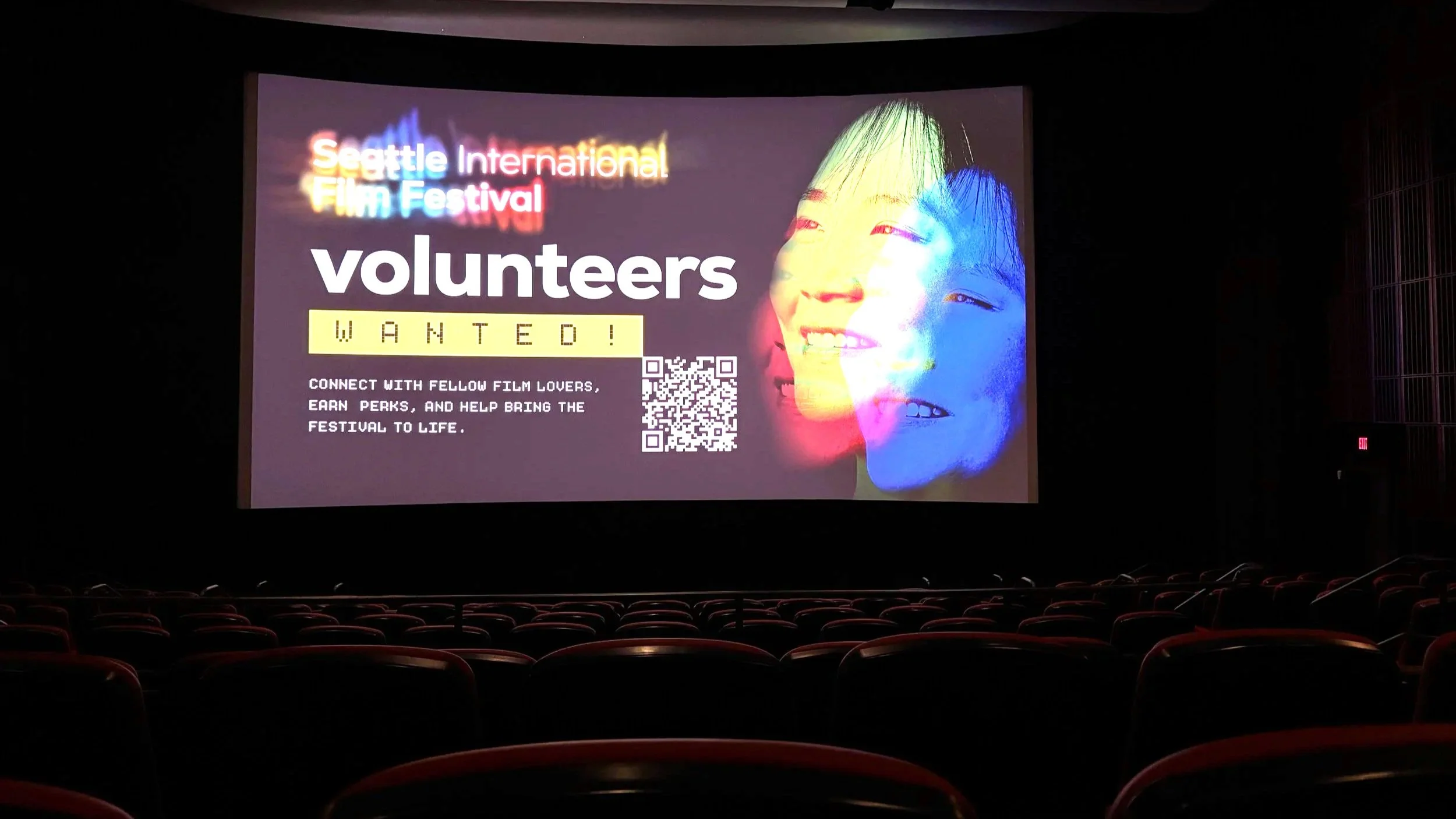 inside theater at SIFF Downtown. Large screen nearly fit for IMAX in dark theater room with red plush chairs.