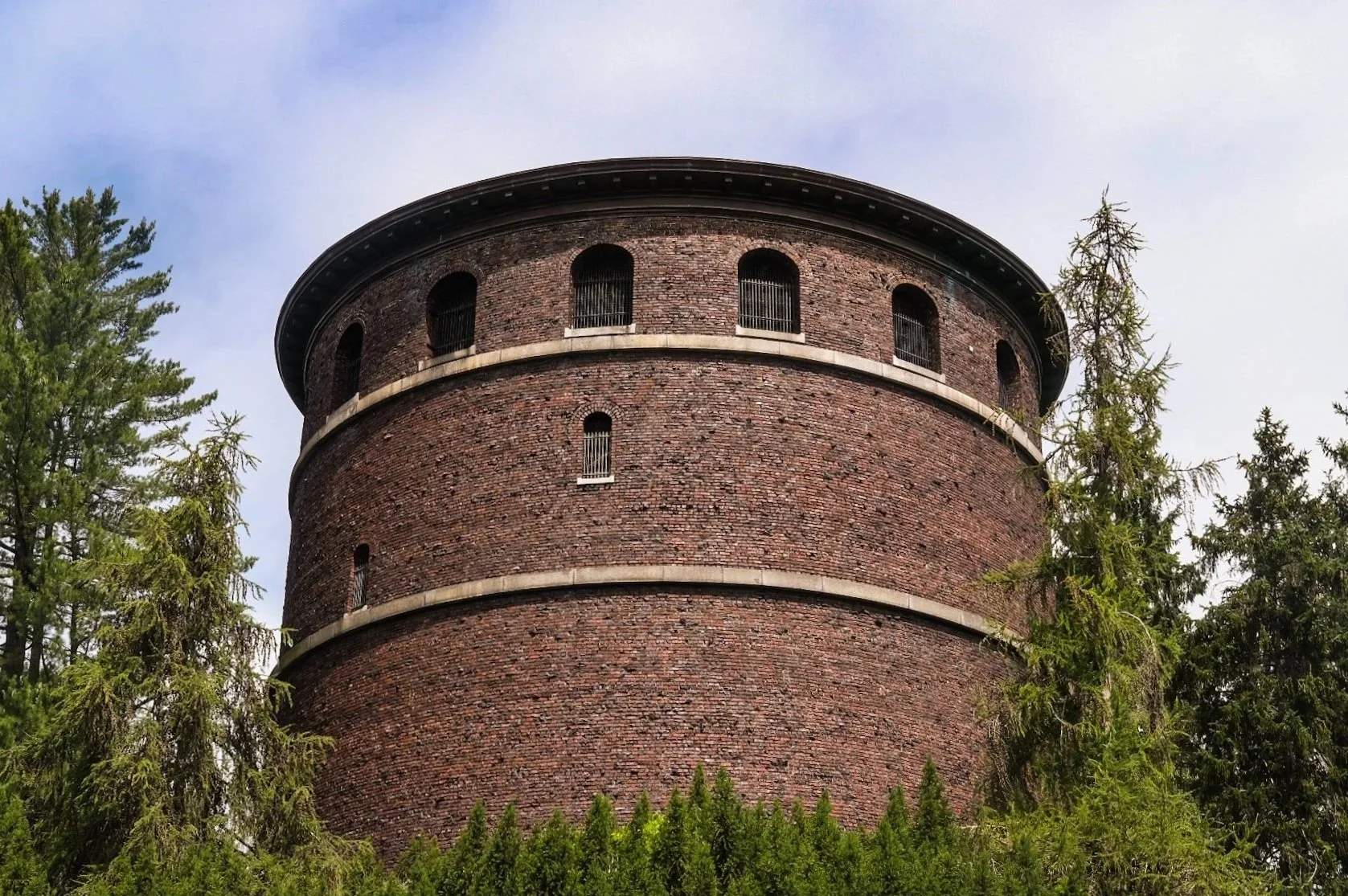 round brick building as the lold water tower at Volunteer Park, surrounded by trees