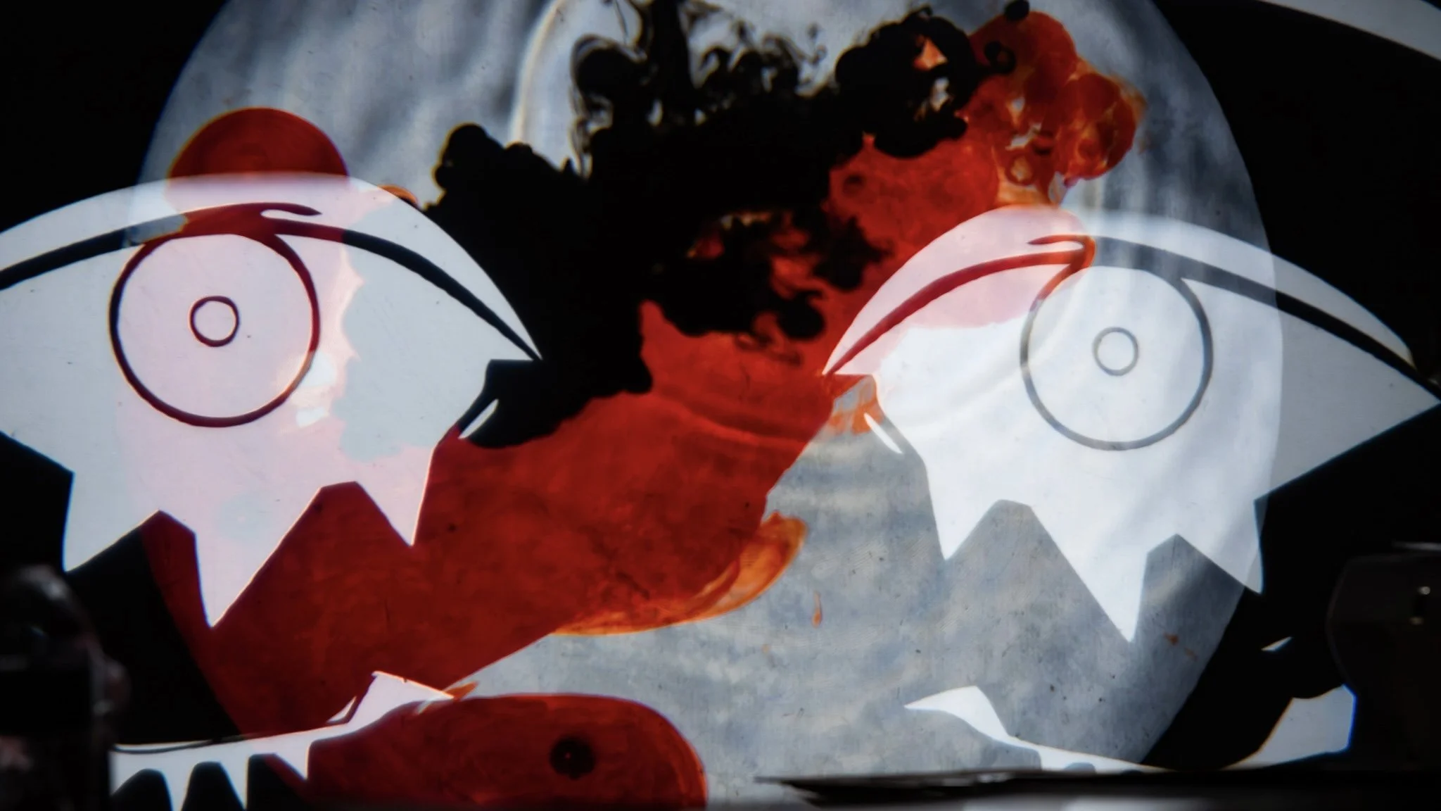 a pair of cutout eyes peer from a pool of red and black liquid mixing
