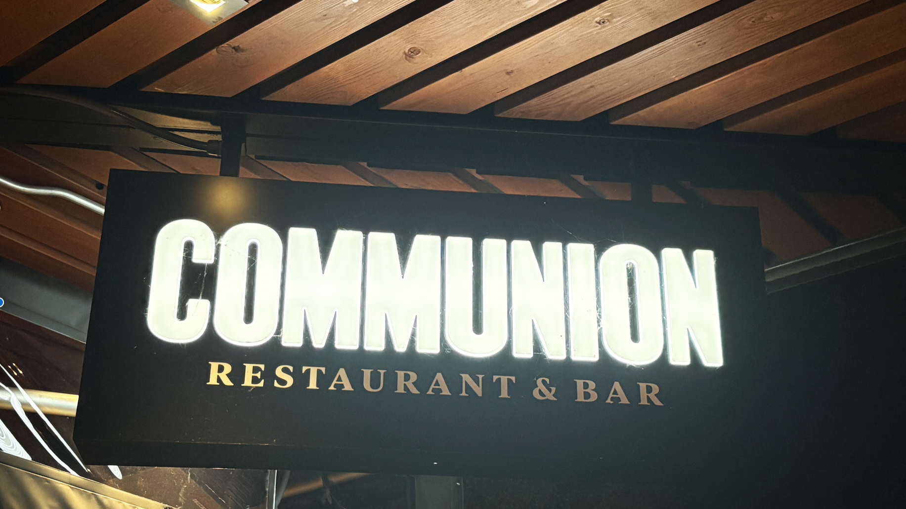 sign for Communion hanging under a roof