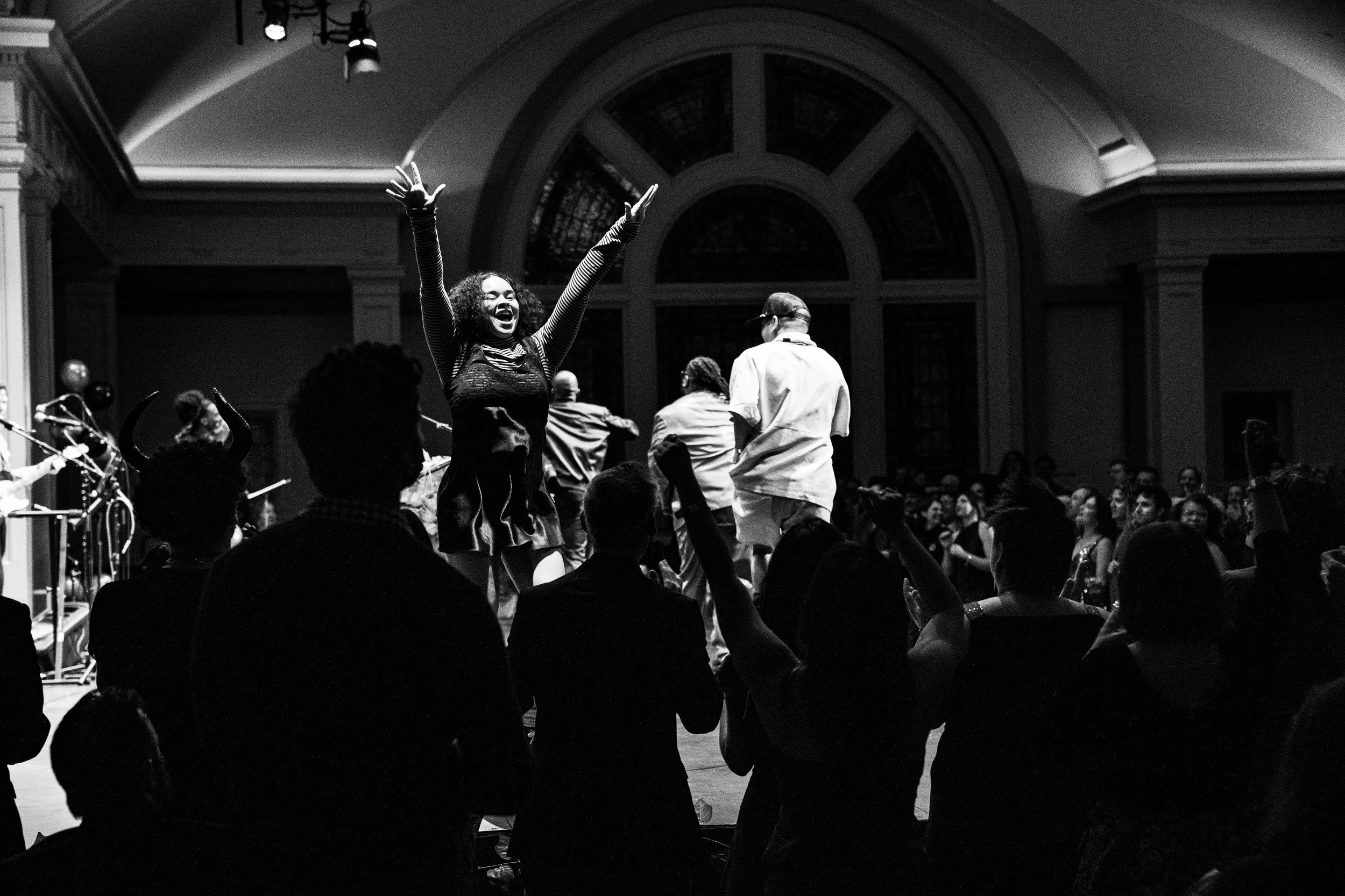 a dancer on stage poses as audience stands and cheers