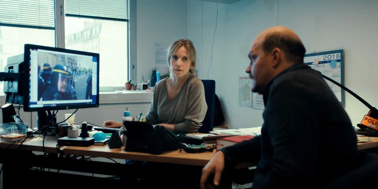 a woman and a man view a video on a computer monitor at a desk in Case 137