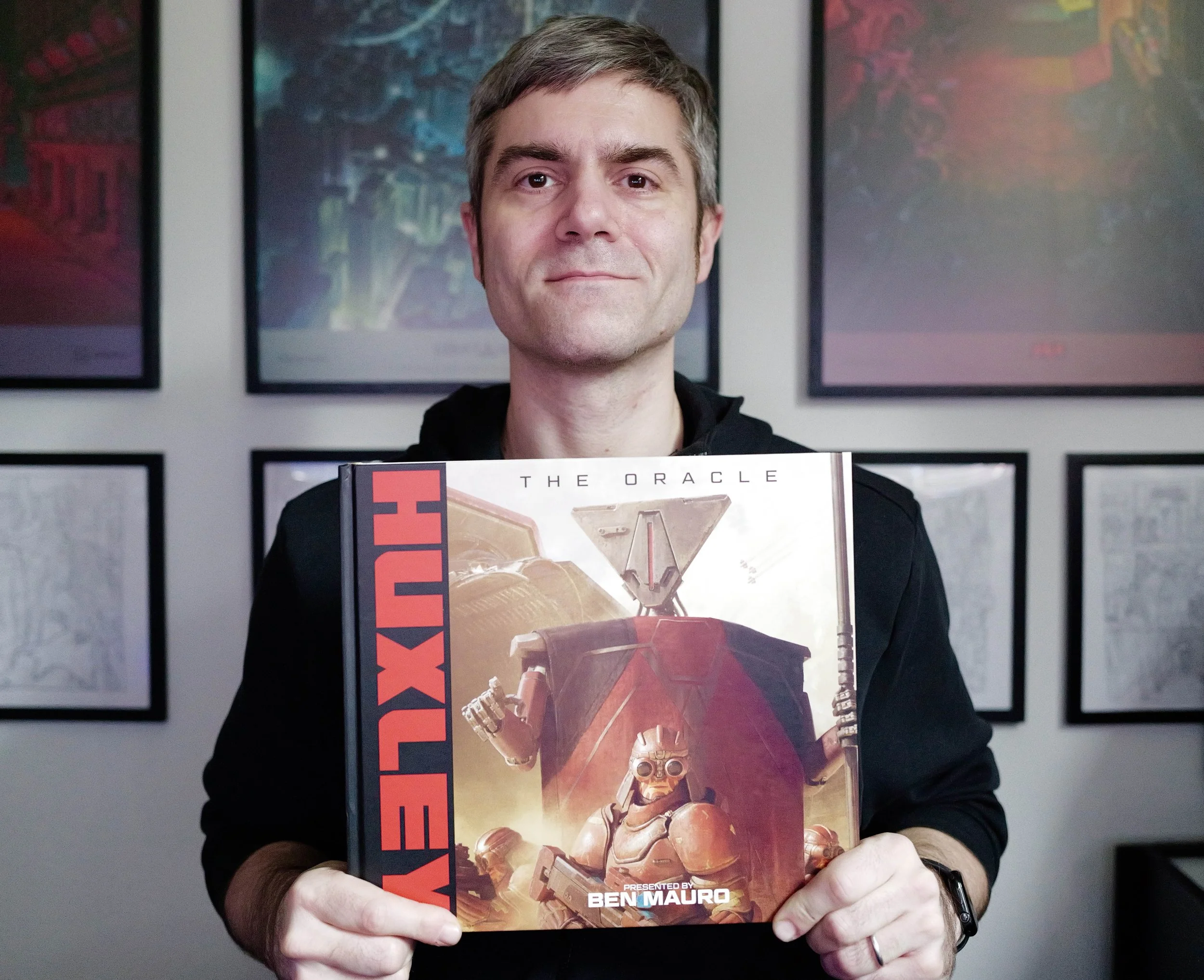 Ben Mauro holding a hardcover copy of Huxley: The Oracle