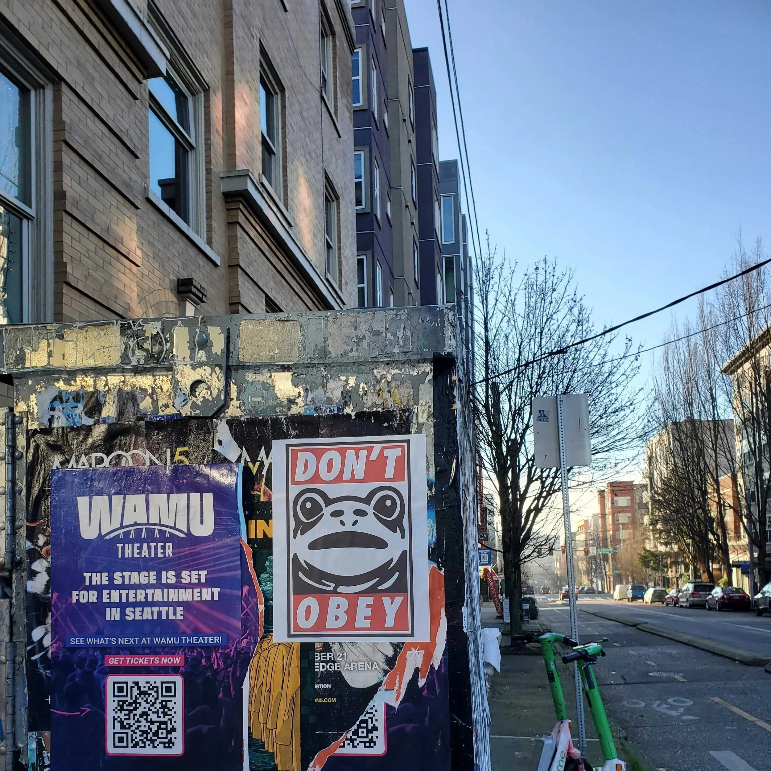 electric box with posters and "Don't Obey" frog graphic