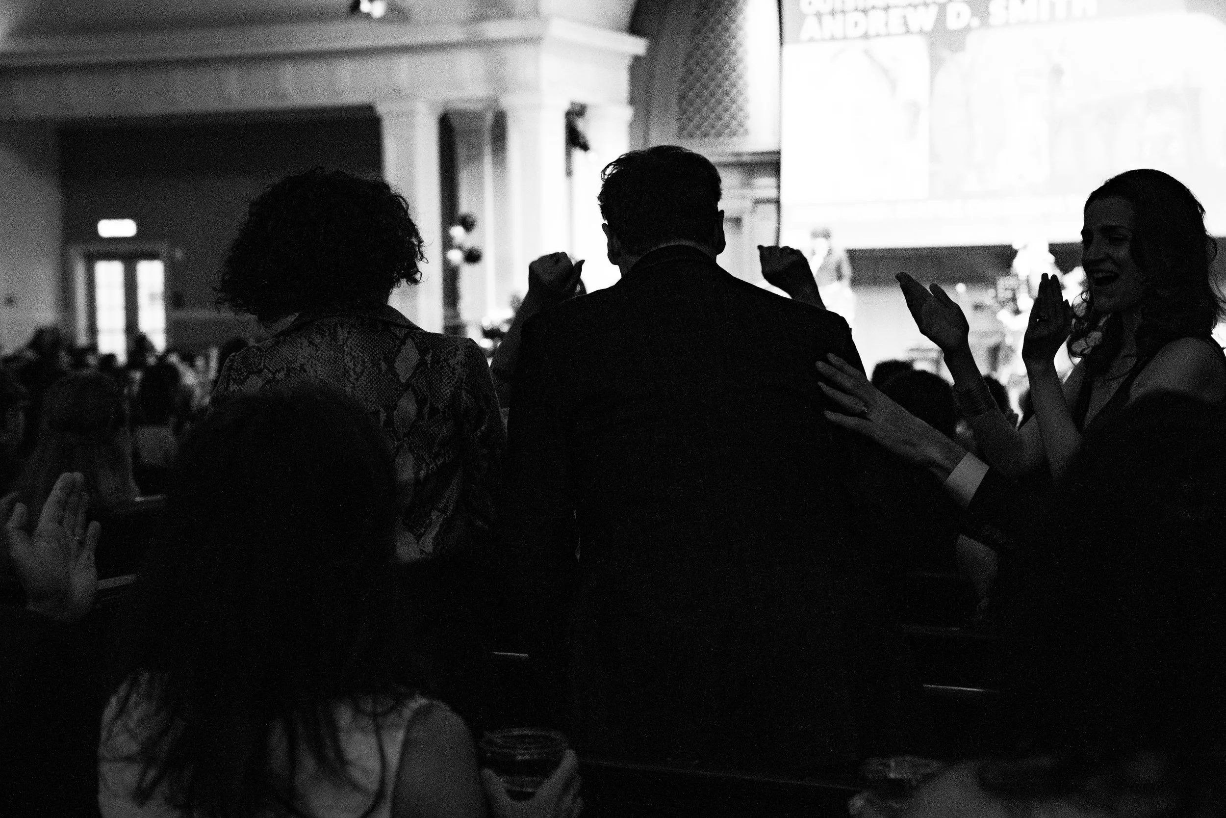 people stand to make their way to stage to accept award