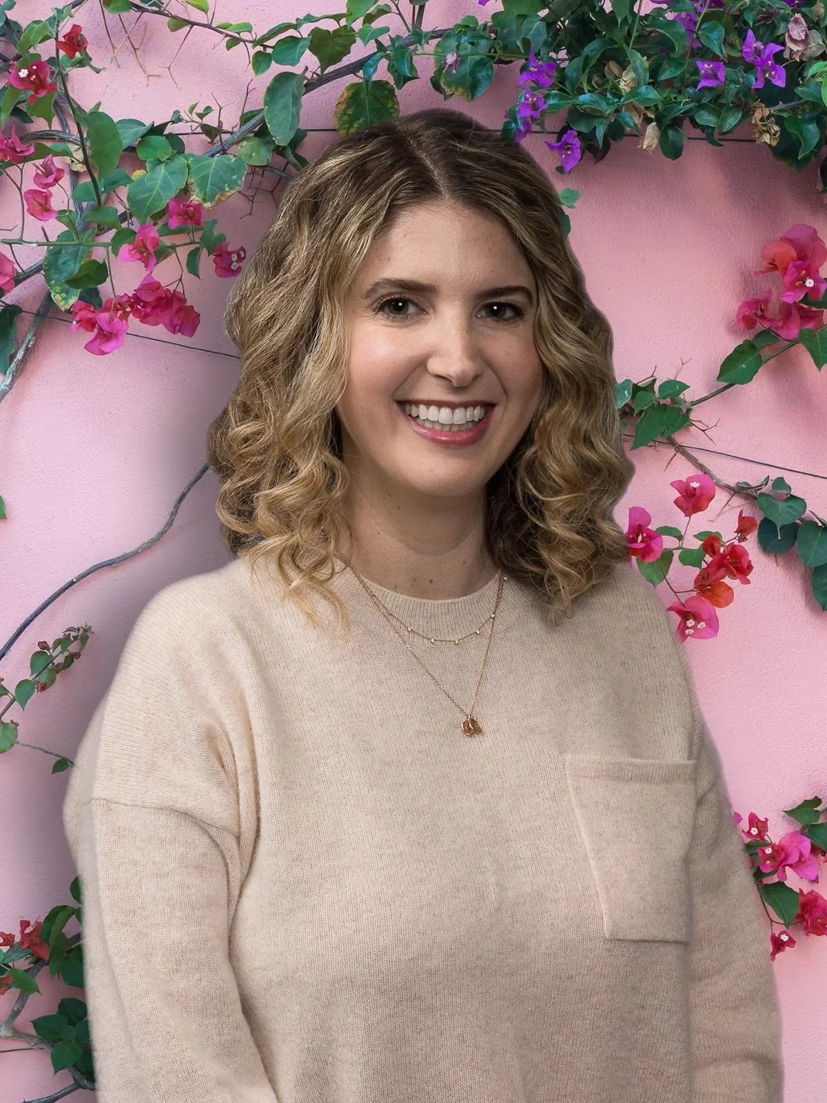 Felicia Andrews, LCSW, smiling in a light pink sweater against a pink floral background.