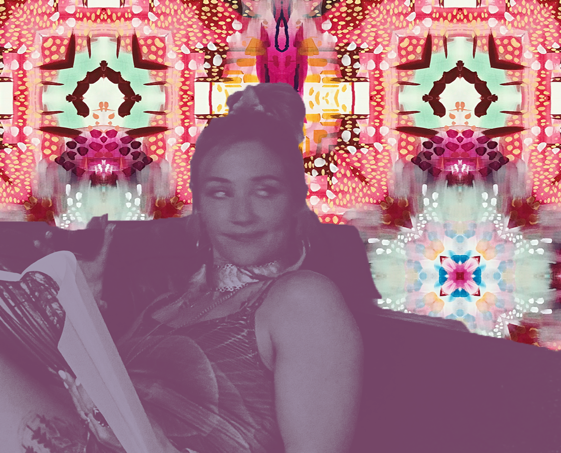 A woman with braided hair styled in a high bun, smiling slightly while looking at a magazine, with a colorful, kaleidoscopic pattern background in red, pink, orange, and blue tones.