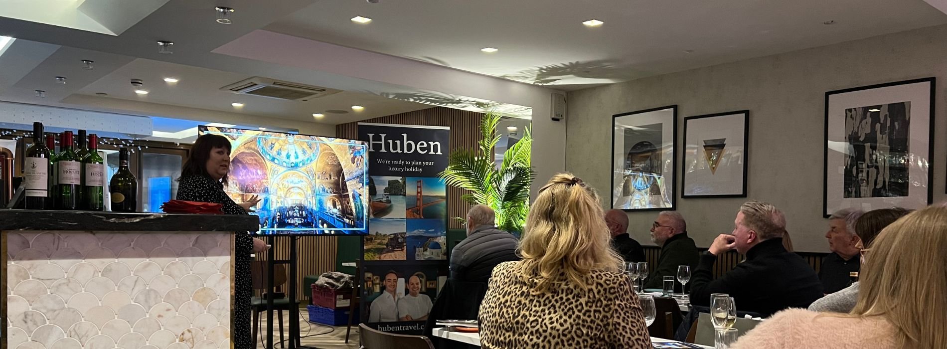Guests listening to a speaker at a Huben Travel hosted evening in The Travel Lounge