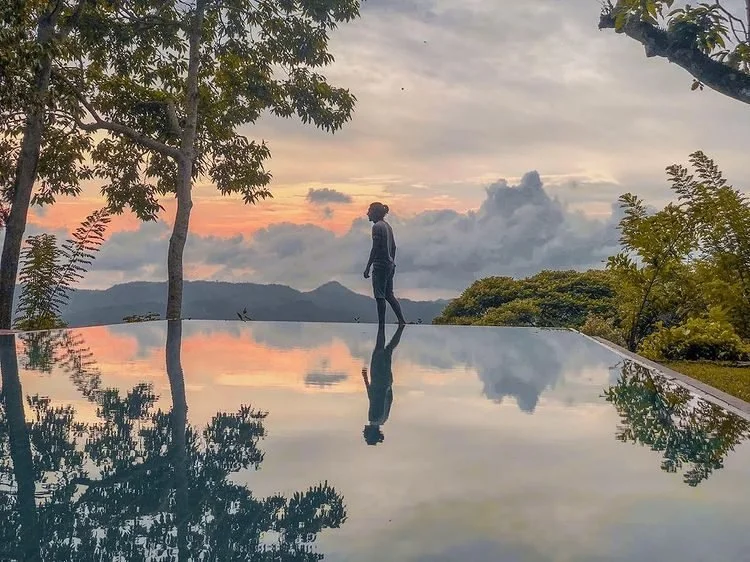 The infinity pool at Mountbatten Bungalow at sunset, with hills beyond