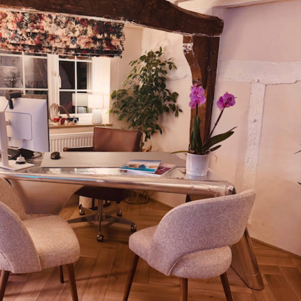 A planning desk with chairs and an orchid in The Travel Lounge