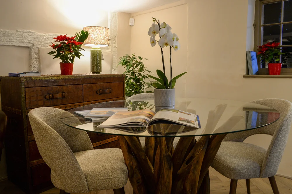 A round table with an orchid and travel brochures in The Travel Lounge