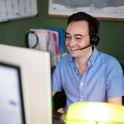 Hugh from Huben Travel on the phone with a guest