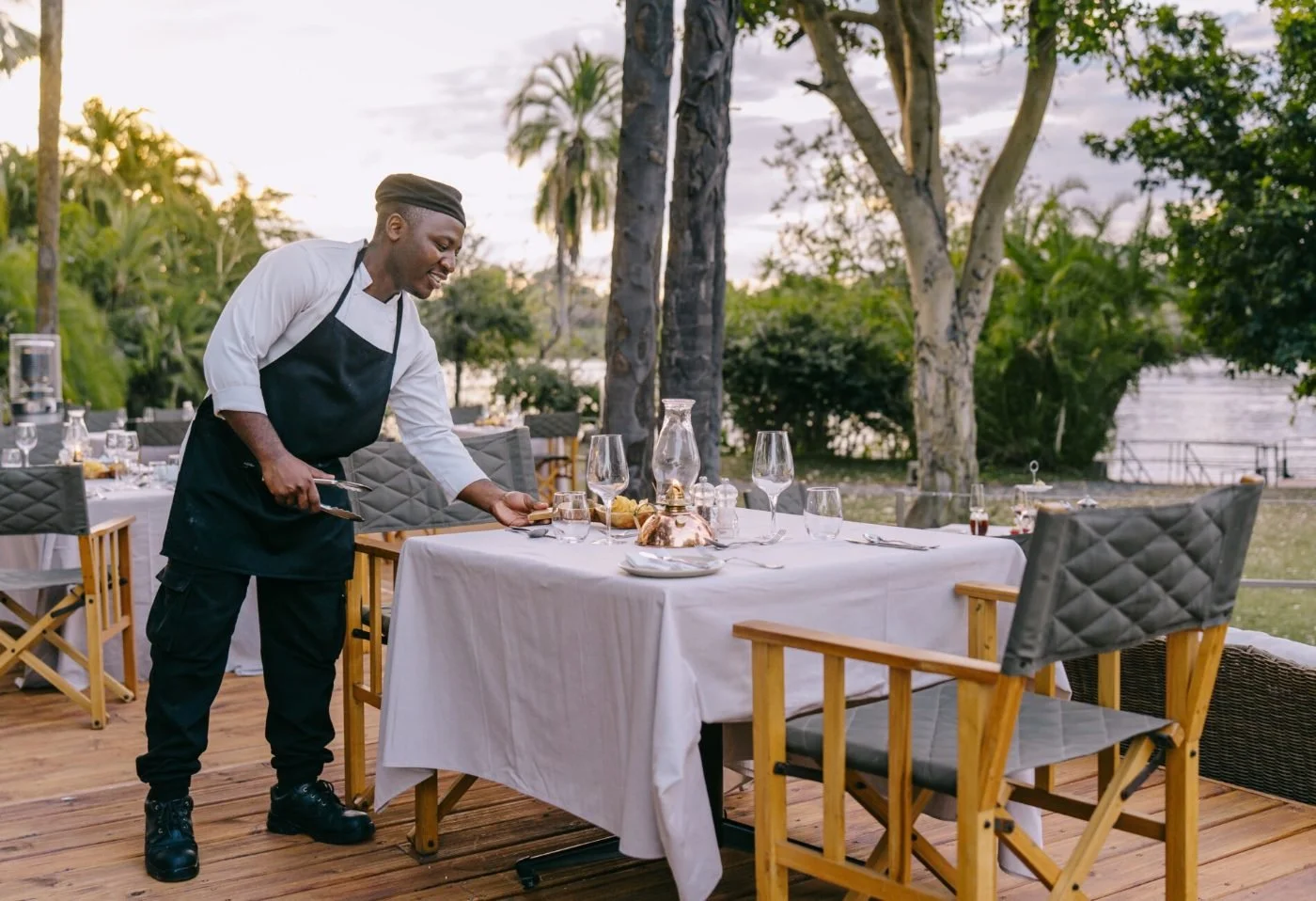 A table set for dinner on the riverbank at The Palm River Hotel