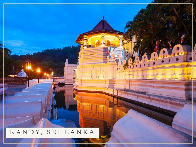 The Temple of the Tooth Relic in Kandy, lit up at dusk and reflected in the moat