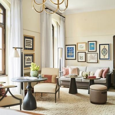 A calm, elegant hotel lounge with armchairs and framed prints