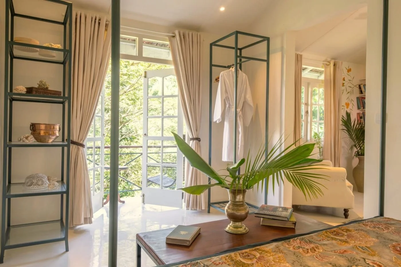 A bright junior suite at The Sun House, with French windows onto the garden
