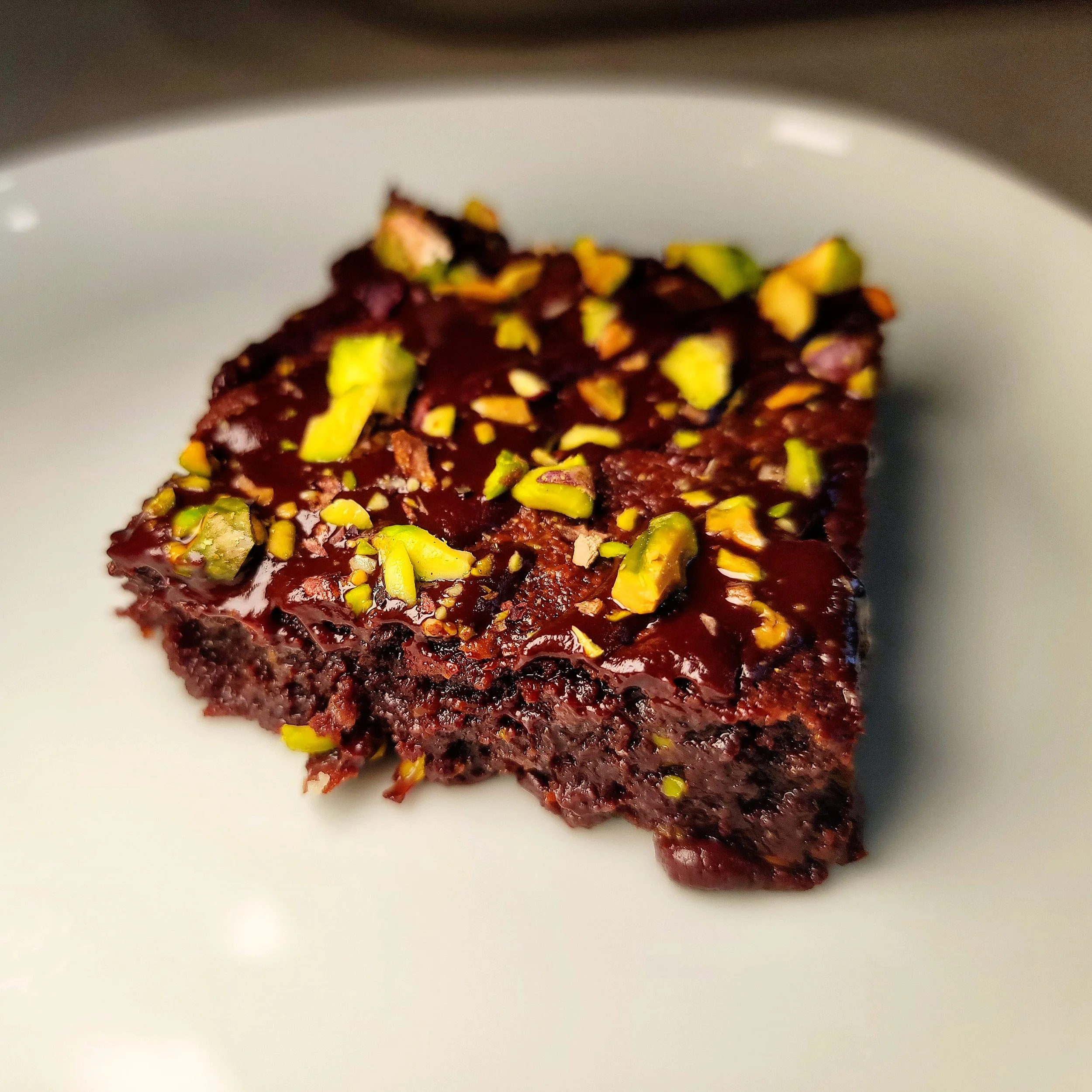 Fudgy chocolate brownie topped with roasted pistachios – decadent dessert for custom dessert tables and Denver-based private events