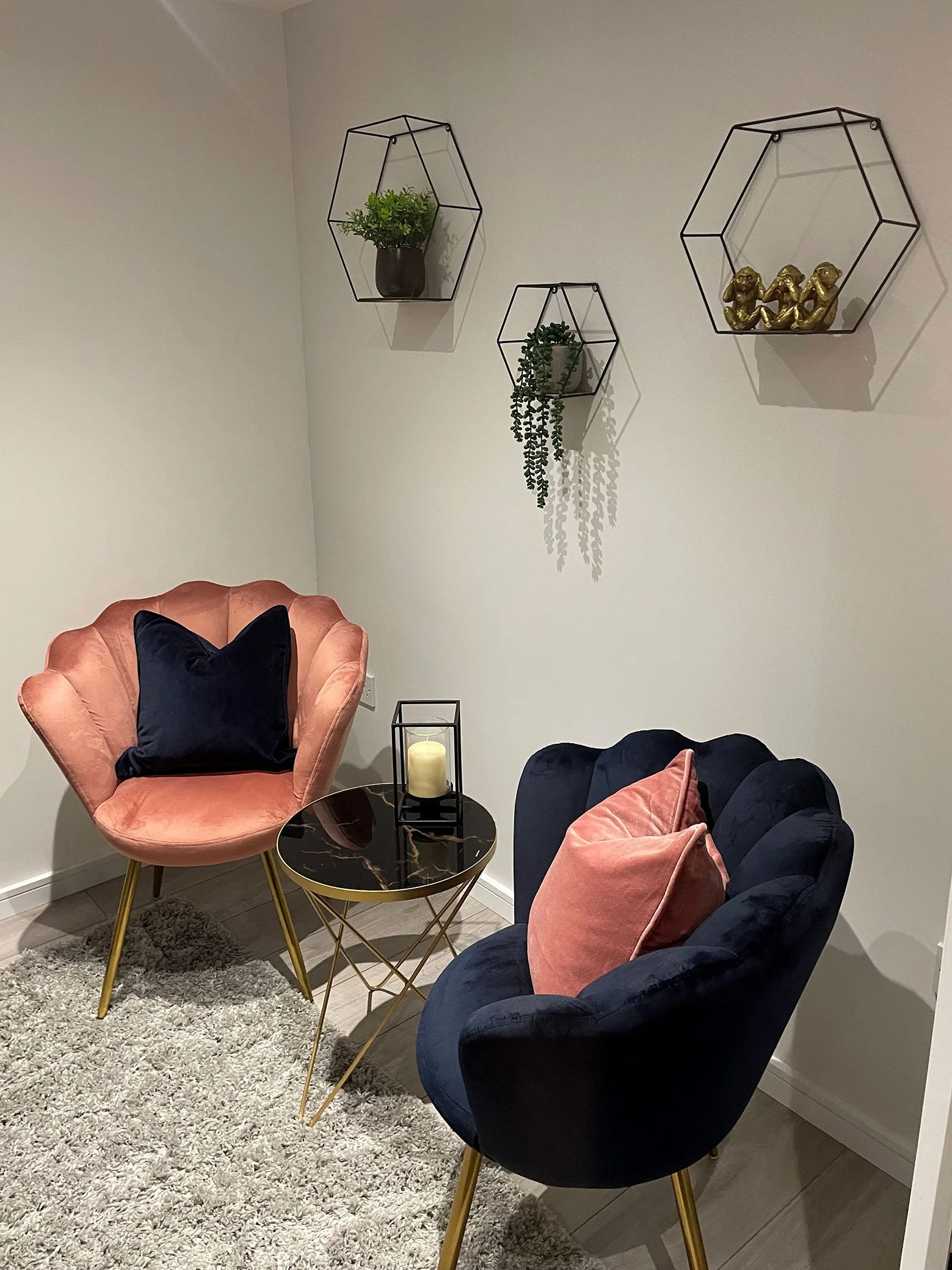  A room featuring two chairs and a table, with a wall hanging adding a touch of elegance. 