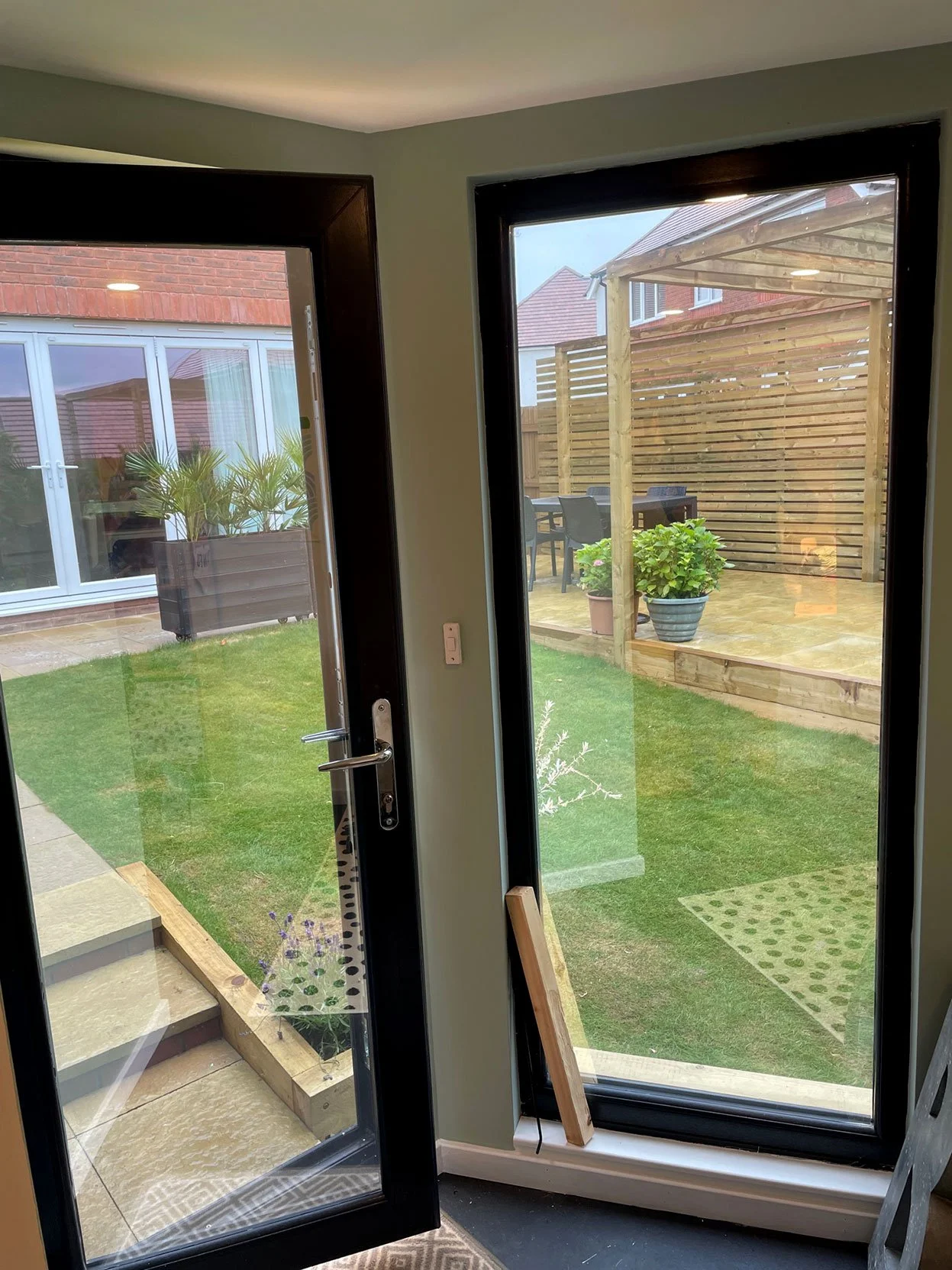  A picturesque view of a patio, complete with a glass door and a wooden fence, providing a seamless blend of indoor and outdoor living. 