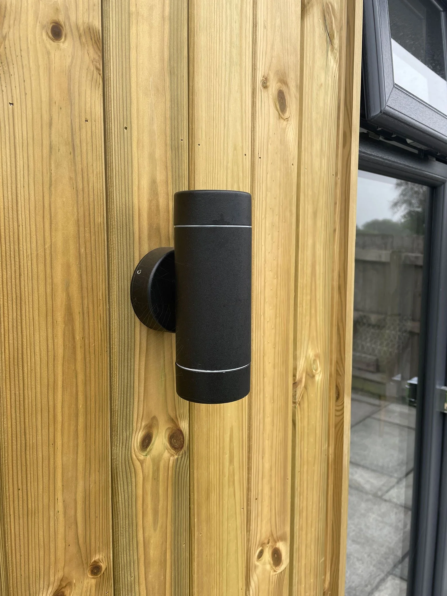 Wall-mounted black outdoor light. 