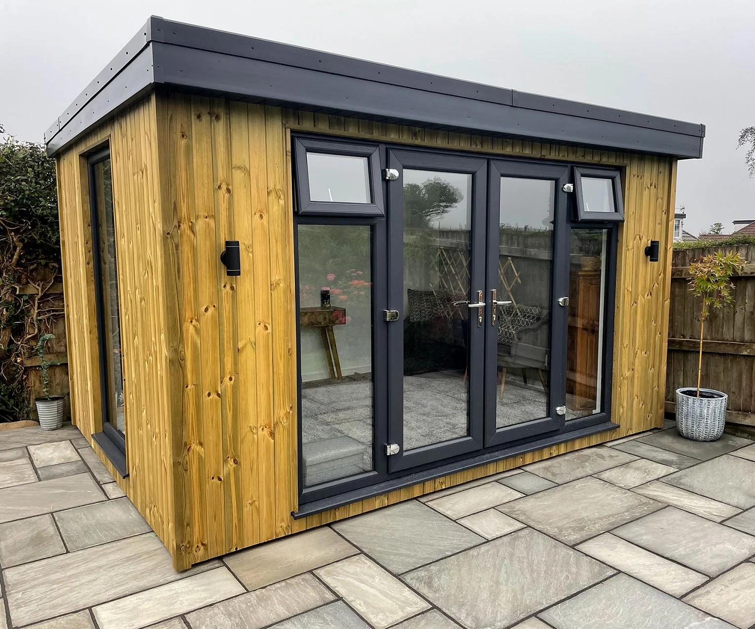  A modern garden office with sleek sliding doors, providing a stylish and functional workspace amidst nature's beauty. 