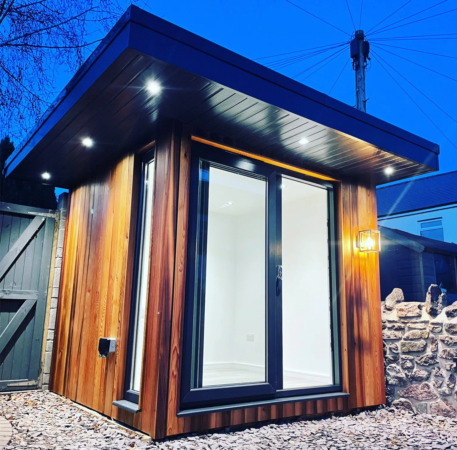  A cozy wooden shed with a charming patio and warm lights, creating a serene and inviting atmosphere. 