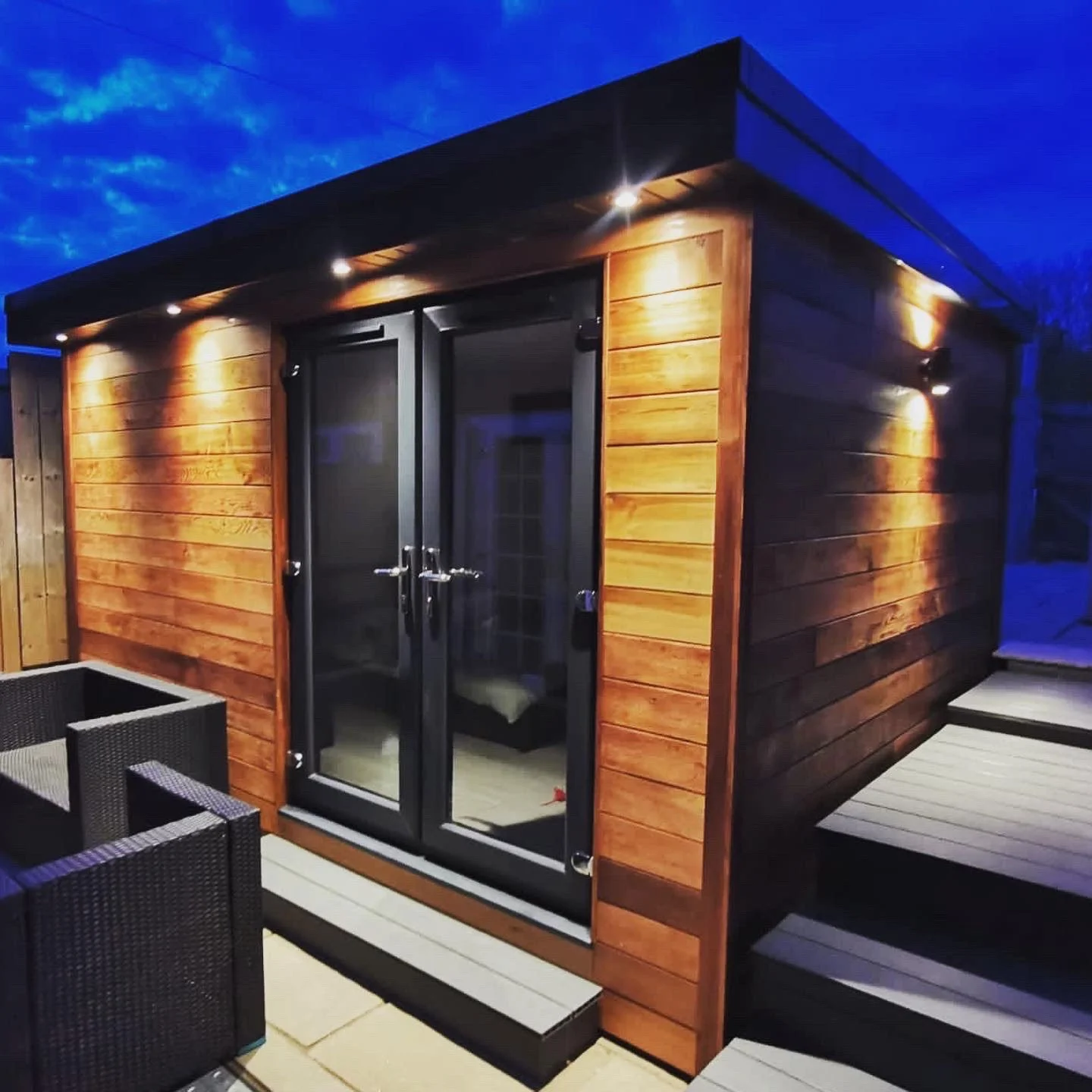  Cozy shed with outdoor seating and lighting. 