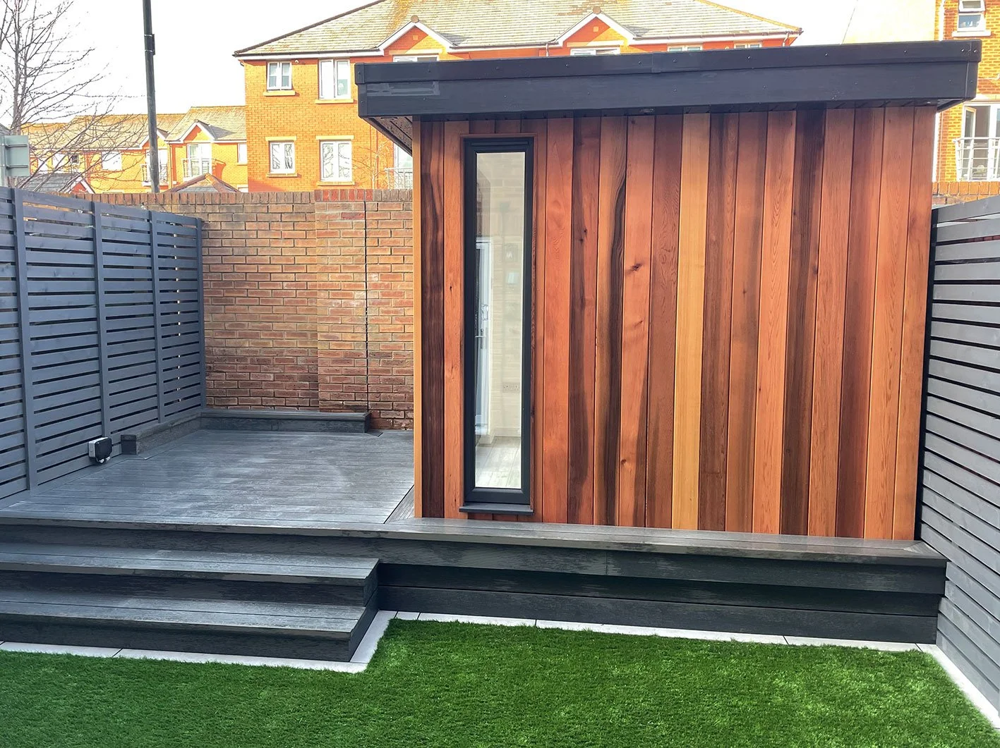  A charming garden enclosed by a wooden fence, featuring a quaint shed. 