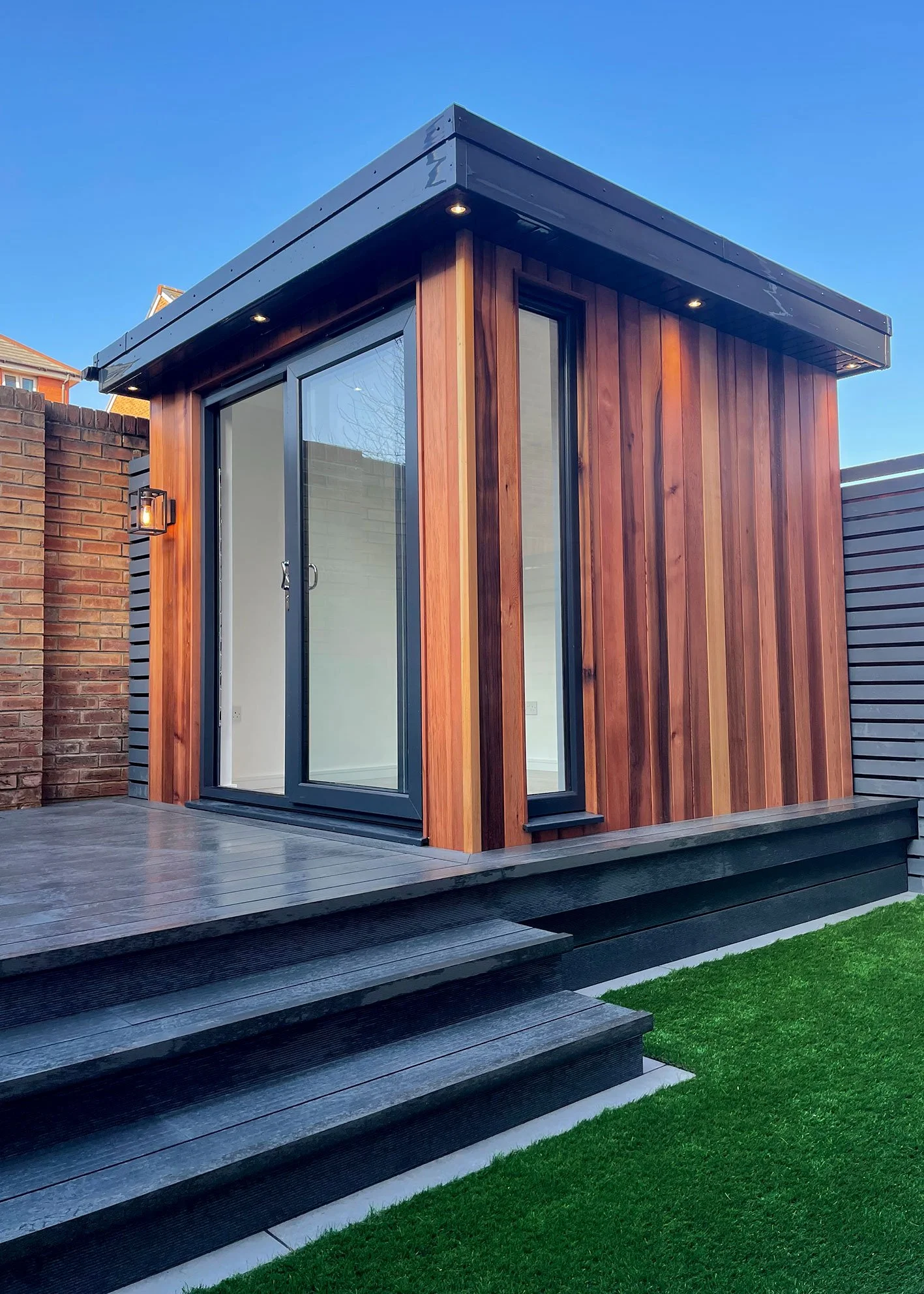  Garden room with wooden deck and glass door. 
