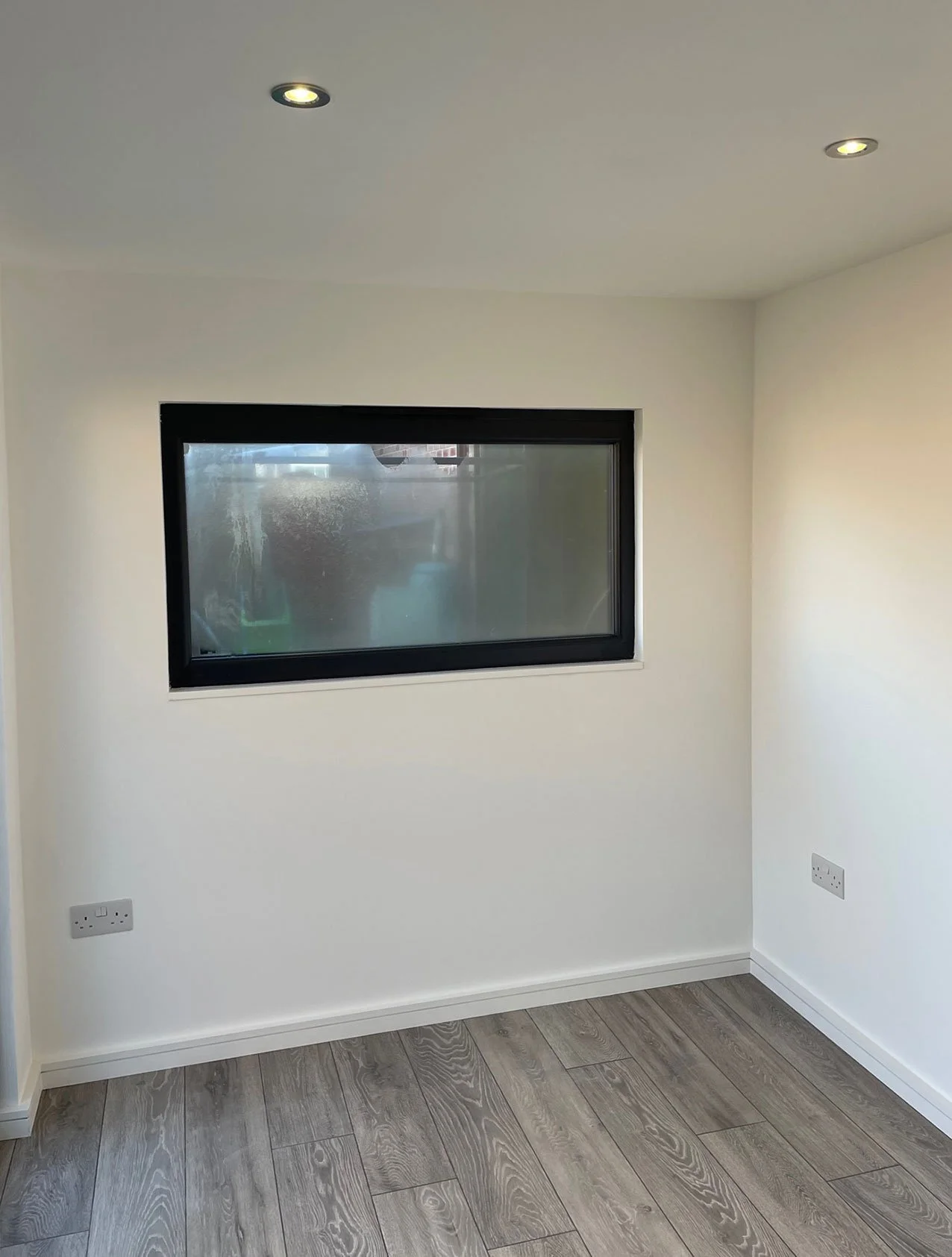  Sunlit room with wooden floor and window. 