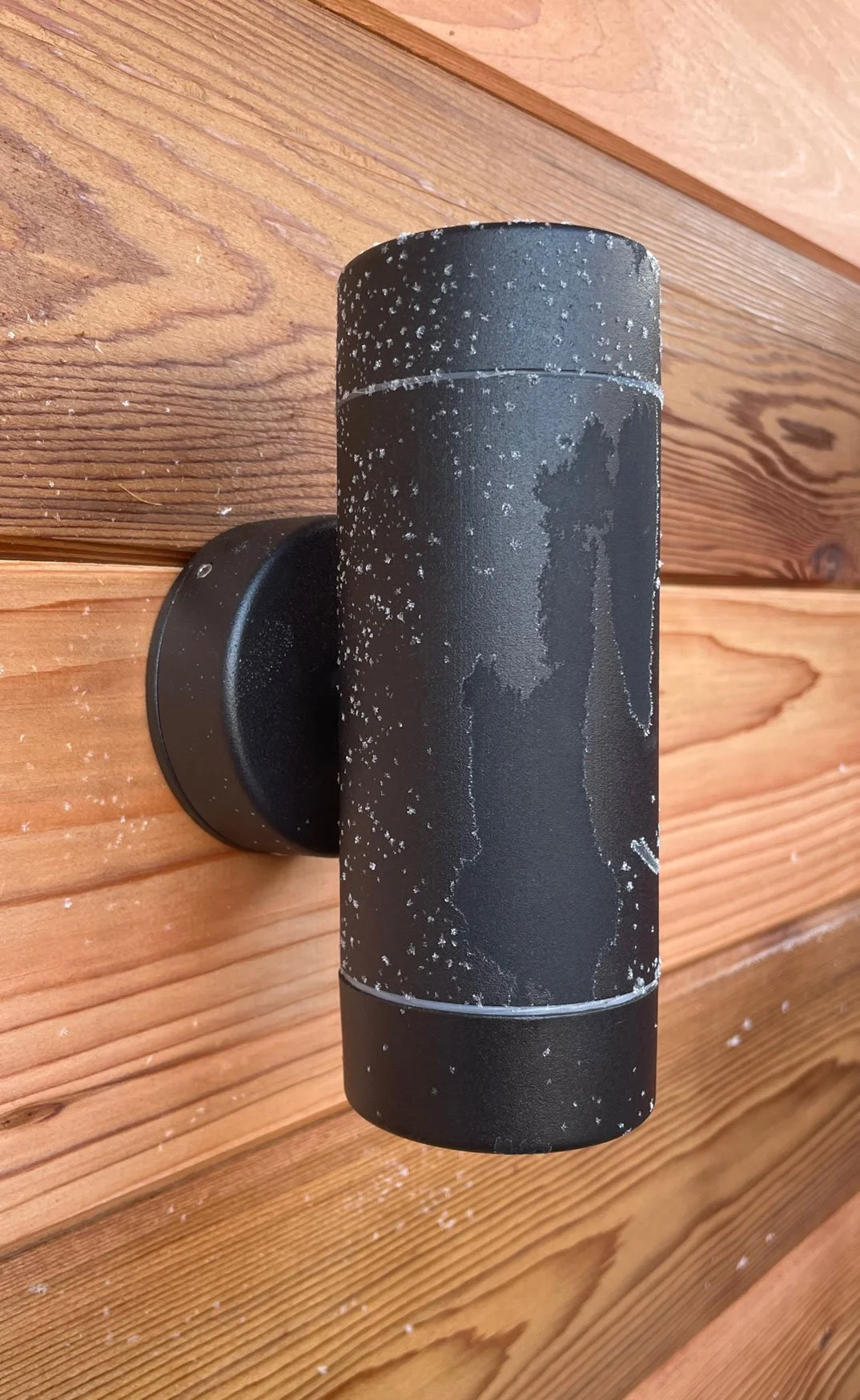  Snowy wooden wall with black uplight. 