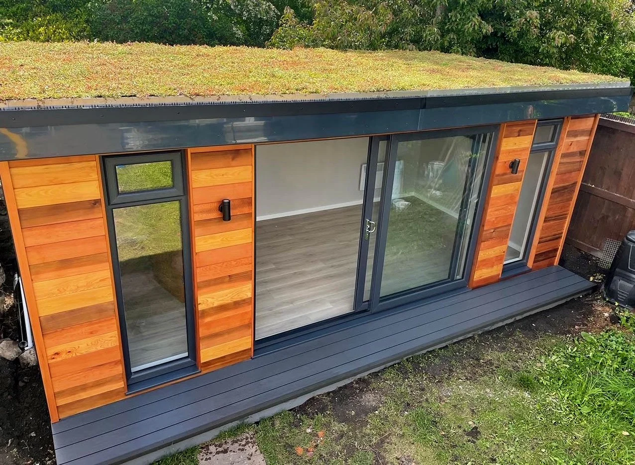  Eco-friendly garden office with a lush green roof, blending seamlessly with nature. 