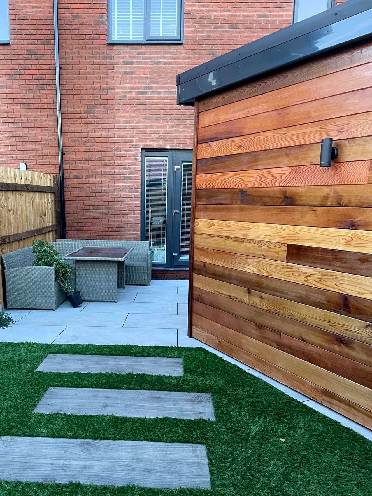  A backyard with a wooden wall and fence, creating a rustic and natural boundary for the outdoor space. 