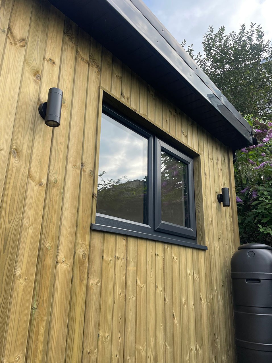  A shed made of wood, complete with a window with waterbutt. 