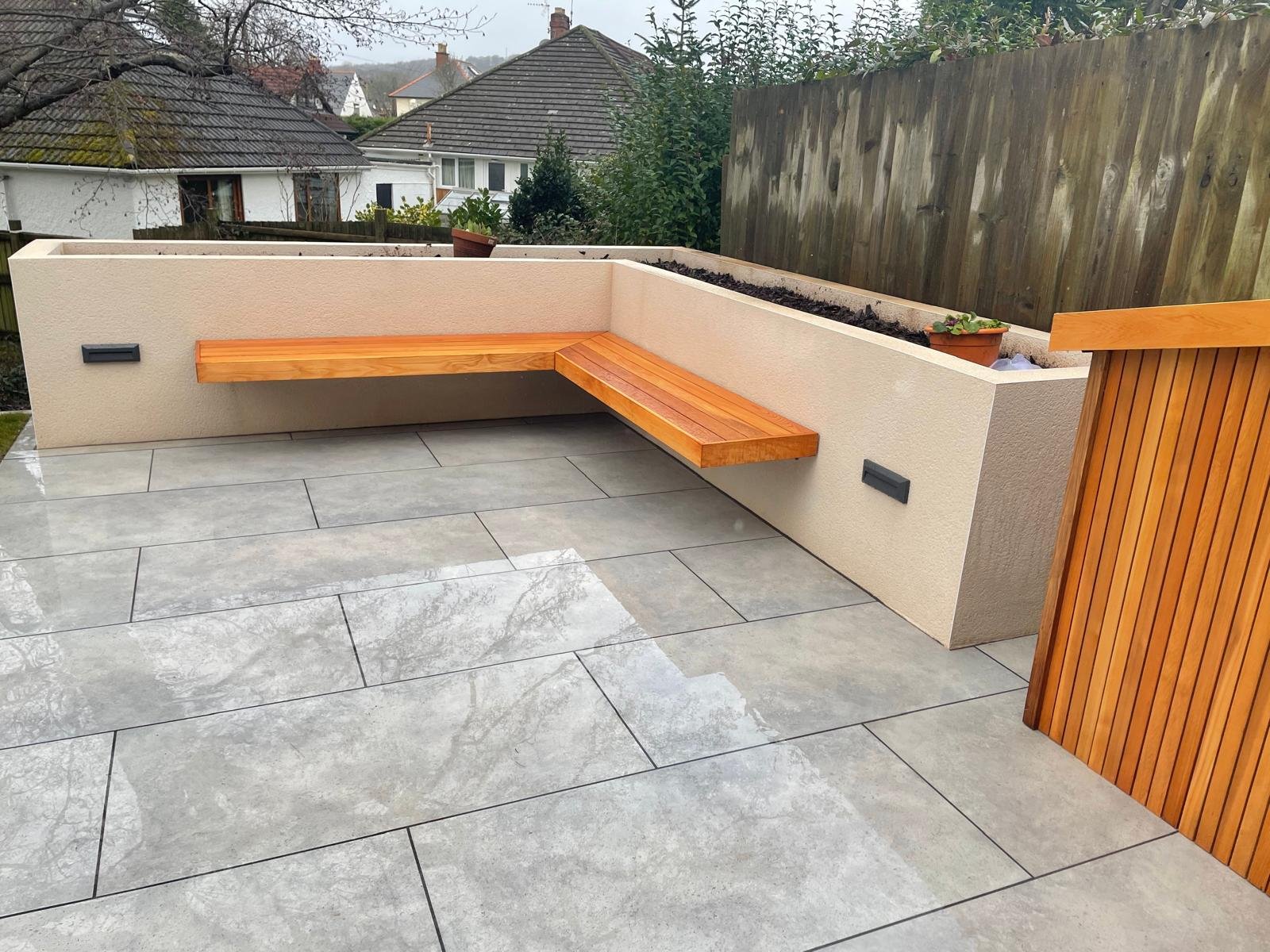 l-shaped-wooden-bench-seating-bespoke-planters-porcelain-paving.jpeg