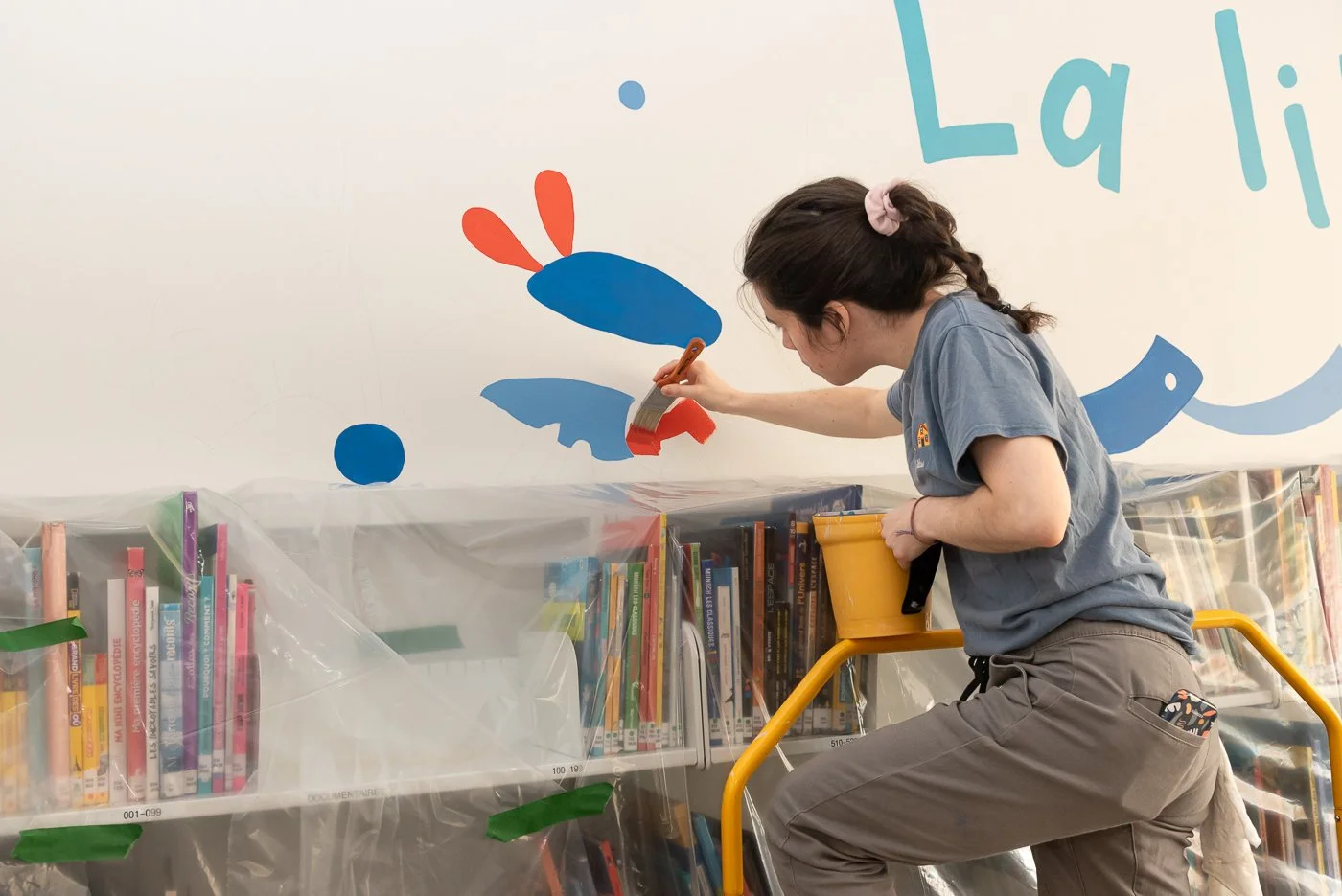Elbé à l'oeuvre sur un détail de sa murale à l'école Notre-Dame-du-Canada à Vanier, Québec