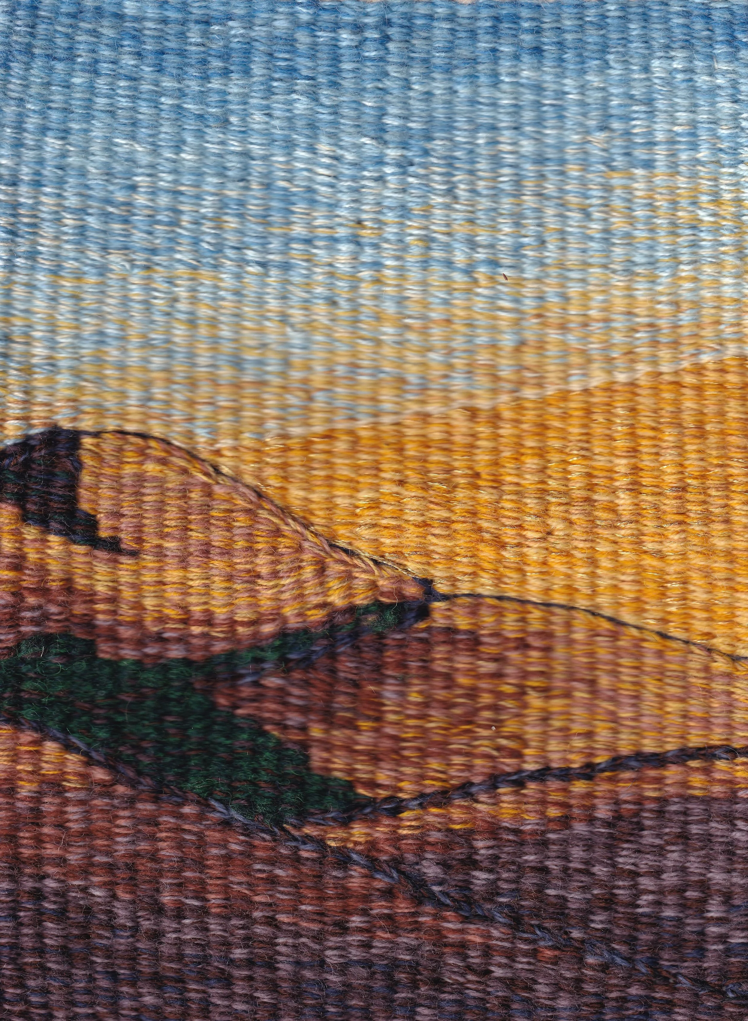 A woven tapestry of golden colored hils with the sun behind them and a California blue sky