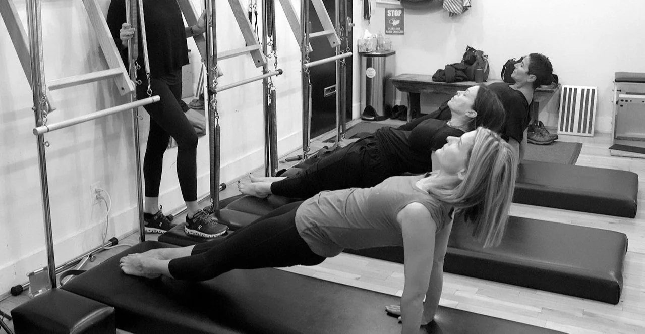 Three women doing matwork pilates with an insturctor.jpg