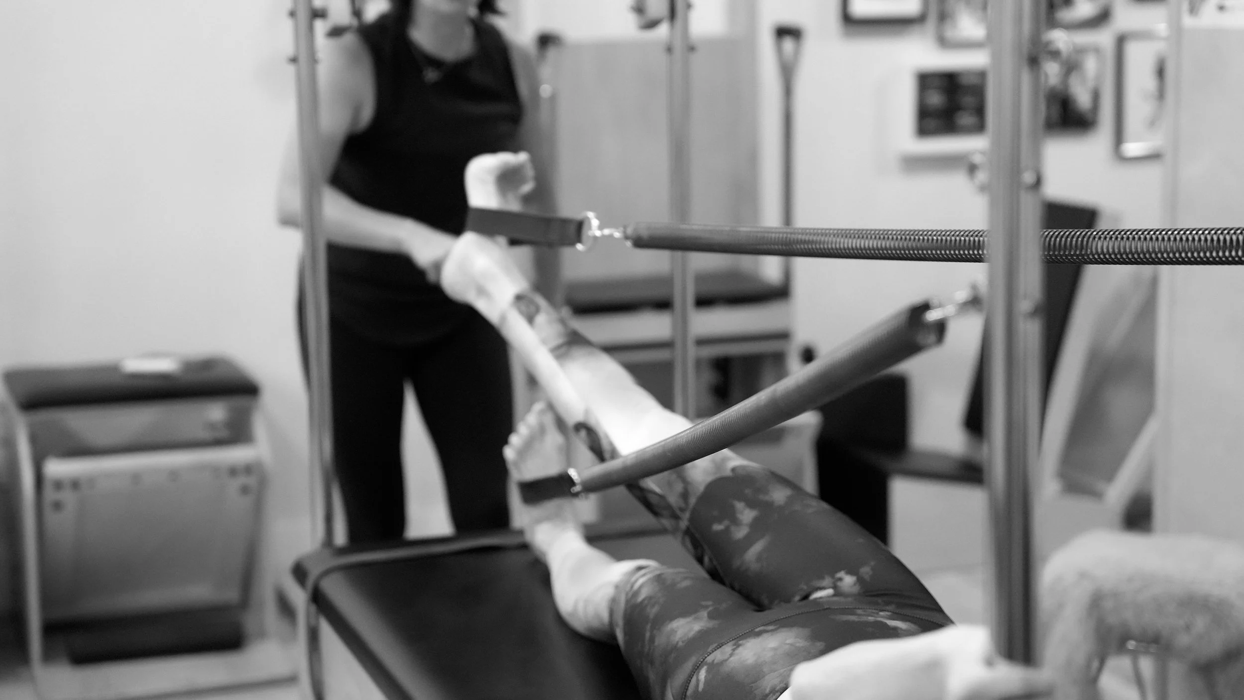 Instructor helping student on a pilates machine.jpg