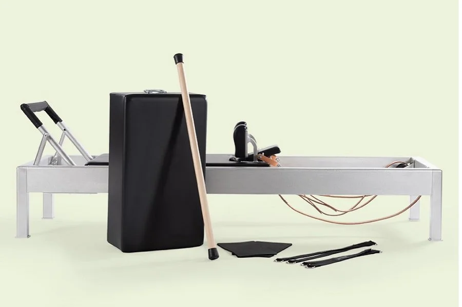Physical therapy or rehabilitation equipment including a wheelchair, cane, crutches, a medication pill organizer, resistance bands, and a bed in a light green room.