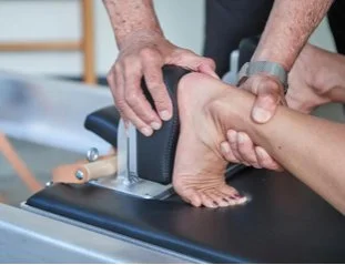 A person receiving a foot massage on a massage table.
