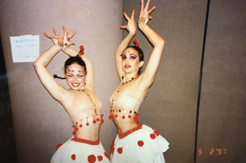 Two young girls in dance uniforms posing