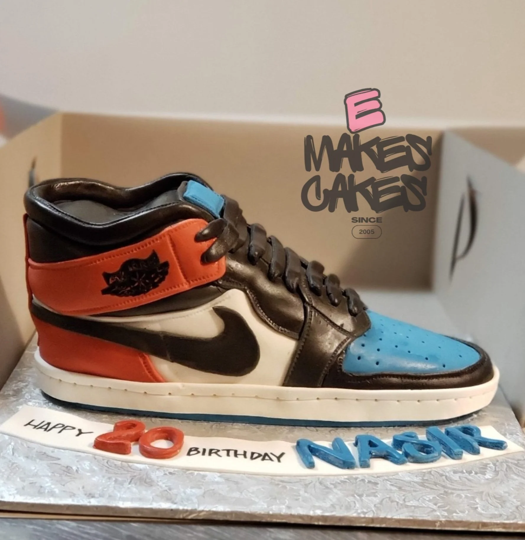 E Makes Cakes, Sculpted sneaker-shaped birthday cake with Nike and Air Jordan design, decorated with red, black, blue, and white colors, placed on a silver cake board, Sculpted cake Indianapolis