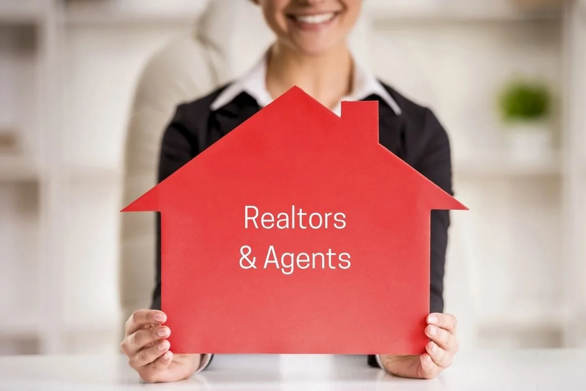 lady holding cutout of house as a spokane real estate agent