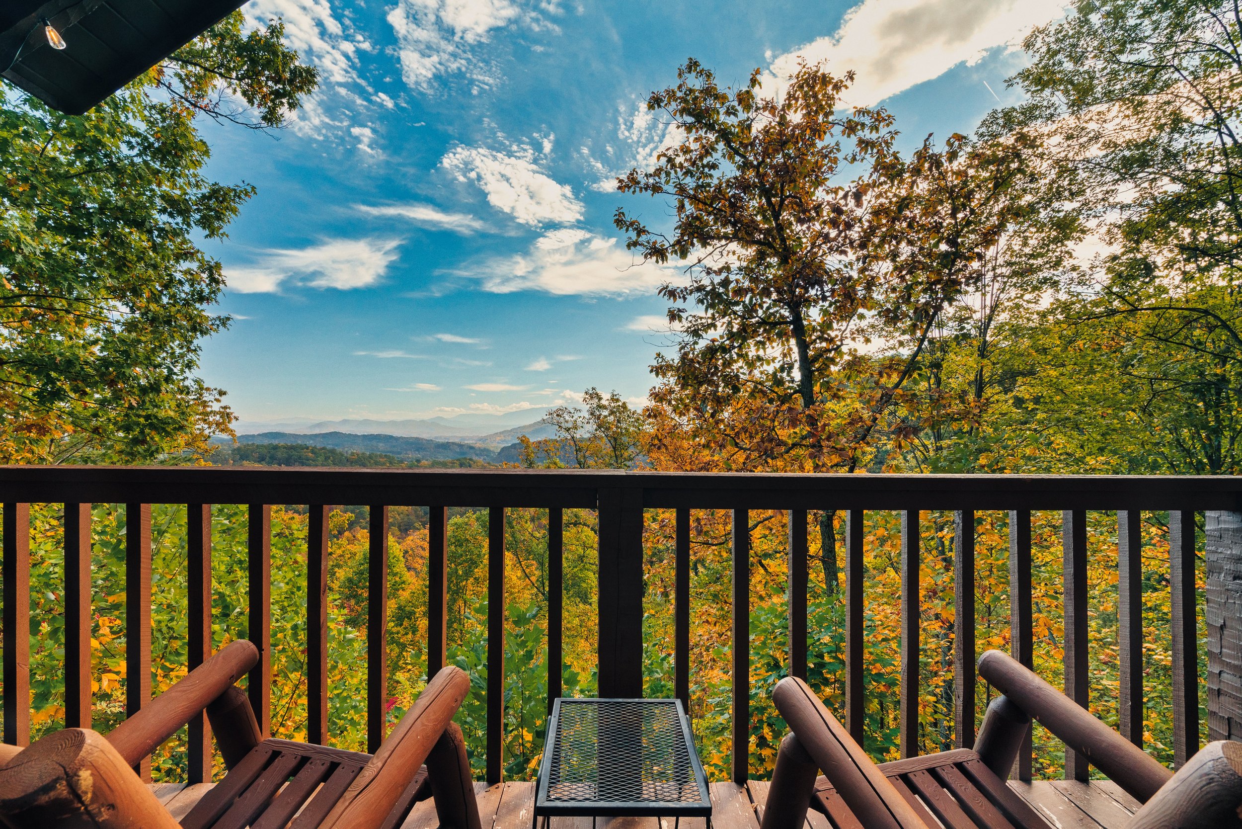 Nestled in a cozy reclining chair on the deck, soak in the vibrant hues of fall. The Smoky Mountains' rolling hills are awash with reds, oranges, and yellows, gently rustling in the crisp breeze. It’s pure tranquility.