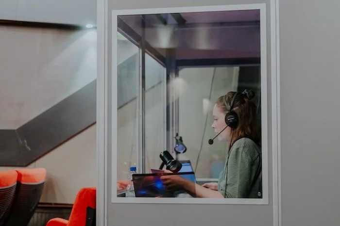 Eine Simultanübersetzerin dolmetscht in einer Dolmetschkabine.